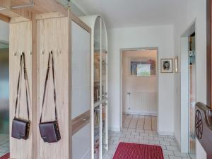 un couloir avec une armoire en bois et un tapis rouge dans l'établissement Cosy Apartment in Oed hling with Garden, à Mauer bei Amstetten