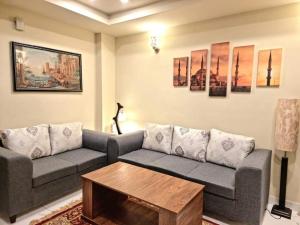 ein Wohnzimmer mit einem Sofa und einem Couchtisch in der Unterkunft Tranquil & Delightful 1 Bed Apt In Bahria Town in Rawalpindi