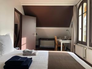 a bedroom with a bed with a desk and a window at LA CHERIELLE in Auvers-sur-Oise