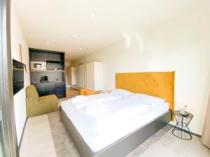 ein kleines Schlafzimmer mit einem Bett und einem Stuhl in der Unterkunft Blackhome Innsbruck City East I contactless check-in in Innsbruck