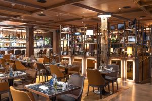 a restaurant with tables and chairs and a bar at Schweizerhof Zermatt - a Small Luxury Hotel in Zermatt