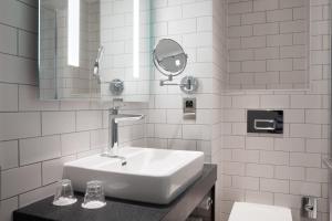 bagno bianco con lavandino e specchio di Holiday Inn Bolton Centre, an IHG Hotel a Bolton