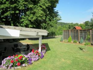 einen Garten mit einem Tisch, Stühlen und Blumen in der Unterkunft Gästehaus Wörner in Durbach