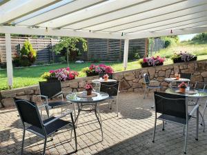 eine Terrasse mit Tischen und Stühlen unter einem weißen Baldachin in der Unterkunft Gästehaus Wörner in Durbach