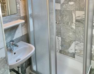 a bathroom with a shower and a sink at Hotel&Hostel Montarina in Lugano