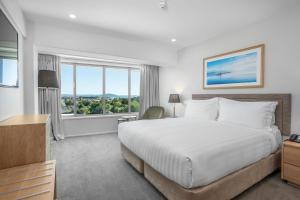 Rydges Rotorua في روتوروا: غرفة نوم بسرير كبير ونافذة كبيرة