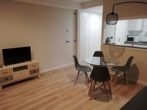 a living room with a table and chairs and a tv at Apartamento Servet, parking gratuito in Bormujos