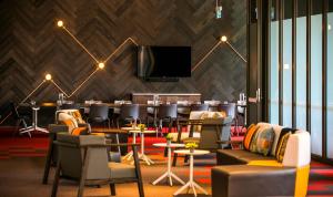 een vergaderruimte met stoelen, een tafel en een tv bij Holiday Inn Express Melbourne Little Collins, an IHG Hotel in Melbourne