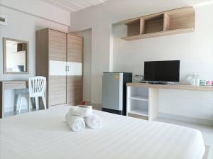 um quarto com uma cama branca e toalhas em JVAPLACE em Nonthaburi