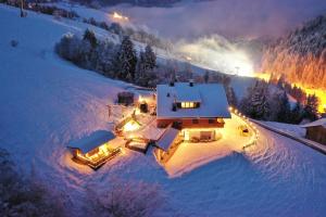 una vista aerea di una casa nella neve di notte di Residenz Erschbaum a Valdaora