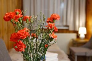 um vaso cheio de flores de laranja sobre uma mesa em Willa 1910 em Karpacz