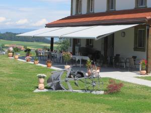 una casa con un toldo blanco en el césped en Le Relais du Château Monney, en Cournillens