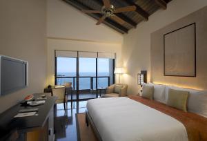 سرير أو أسرّة في غرفة في The Leela Kovalam, A Raviz Hotel