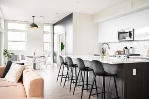 una cucina e un soggiorno con divano e sgabelli da bar di Skyline Loft - Sweeping Views - Central LoHi a Denver