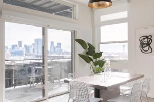 una sala da pranzo con tavolo, sedie e finestra di Skyline Loft - Sweeping Views - Central LoHi a Denver