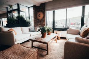 een woonkamer met witte banken en een salontafel bij Strandhotel Zoutelande in Zoutelande