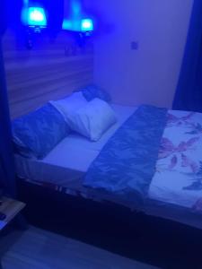 een bed in een donkere kamer met blauwe verlichting bij MTA Lounge and Leisures in Enugu