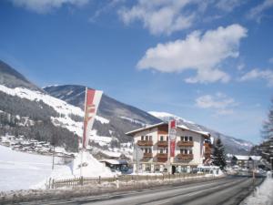 un hôtel dans les montagnes avec de la neige au sol dans l'établissement Aparthotel Garni Schranz, à Wald im Pinzgau