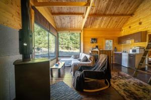 uma sala de estar com um fogão numa casa em Wood Cabin by the River - for Nature Lovers em Vytina