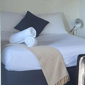 a bed with white sheets and pillows on it at Batemans Bay Holiday Park & Hostel in Batemans Bay