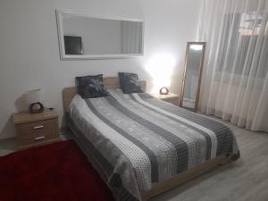 1 dormitorio con cama, ventana y espejo en New 33, en Bacău