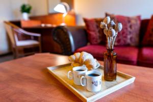 a tray with two cups of coffee and croissants on a table at Hotel U Vlašského Dvora in Kutná Hora