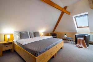 a bedroom with a large wooden bed in a attic at Hotel U Vlašského Dvora in Kutná Hora