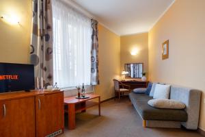 a living room with a couch and a tv at Hotel U Vlašského Dvora in Kutná Hora