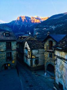 eine Gruppe von Gebäuden mit einem Berg im Hintergrund in der Unterkunft Apartamentos Valle de Ordesa-Torla in Torla-Ordesa