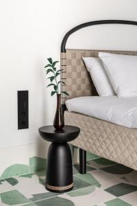 eine Vase auf einem Tisch neben einem Bett in der Unterkunft Concepcio by Nobis, Palma, a Member of Design Hotels in Palma de Mallorca