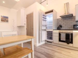 a kitchen with white appliances and a wooden table at Battell Chambers in Camborne