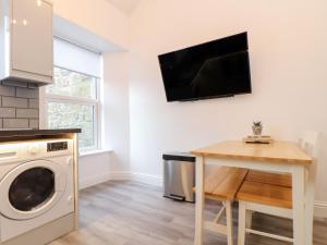 a laundry room with a washing machine and a table at Battell Chambers in Camborne