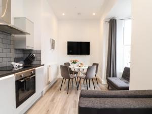 a kitchen and living room with a table and chairs at Baker Chambers in Camborne