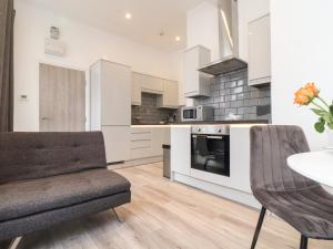 a kitchen with white cabinets and a table and chairs at Baker Chambers in Camborne