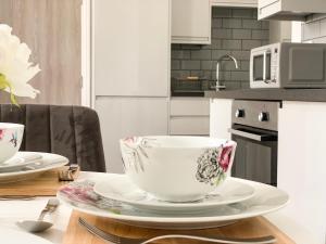 a white cup and saucer on a table in a kitchen at Baker Chambers in Camborne