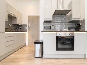 a kitchen with white cabinets and a stove at Baker Chambers in Camborne