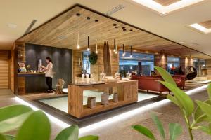 a woman standing at a counter in a lobby at Hotel Lac Salin Spa & Mountain Resort in Livigno