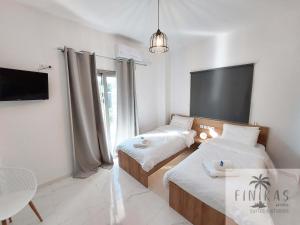 A bed or beds in a room at FINIKAS Suites & Apartments 10min from Athens Airport