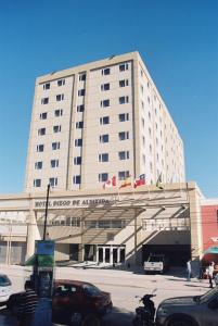 un grand bâtiment avec des voitures garées devant lui dans l'établissement Hotel Diego de Almagro Copiapo, à Copiapó