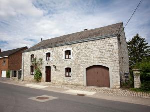 a large stone building with a large garage at Spacious Holiday Home in Humain with Garden in Marche-en-Famenne