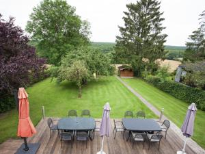 two tables and chairs with umbrellas on a deck at Spacious Holiday Home in Humain with Garden in Marche-en-Famenne