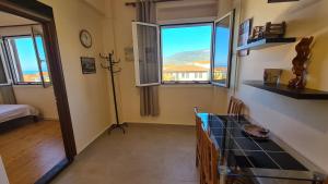 Cette chambre dispose de deux fenêtres et d'une table avec vue. dans l'établissement Sea And Sun apartments 303 Ιδιωτικό διαμέρισμα, à Kardamyli