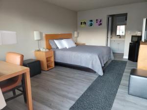 a bedroom with a bed and a table and a chair at Garden of the Gods Motel in Colorado Springs