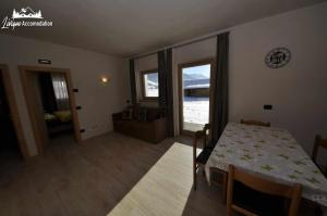 een eetkamer met een tafel en een kamer met uitzicht bij Al Bait da Valeriano by Livigno Accomodation in Livigno