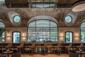 um bar com mesas e cadeiras numa sala com janelas em Hotel Lutetia em Paris