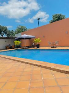 einen Pool mit einem Tisch und einem Sonnenschirm in der Unterkunft class hotel in Brazzaville