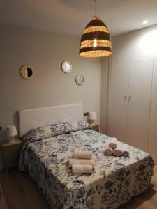 a bedroom with a bed with towels and a chandelier at Apartamento Servet, parking gratuito in Bormujos