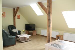 a living room with two chairs and a tv at Ferienwohnung am Schlosssee. in Penkun