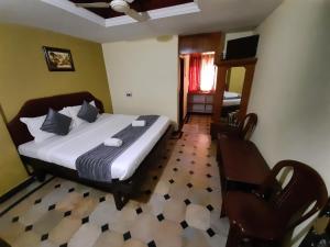 - une chambre avec un lit et une chaise dans l'établissement HOTEL CAVERI COMFORT INN, à Madikeri