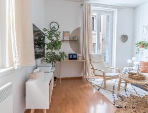 uma sala de estar branca com uma secretária e uma cadeira em Appartement 1er étage piéton Place de la Pierre em Valence